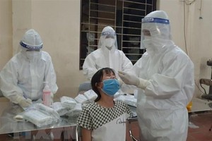 Lực lượng y, bác sỹ lấy mẫu xét nghiệm SARS-CoV-2 cho người dân. (Ảnh: Thanh Thương/TTXVN).