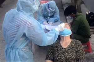 Xét nghiệm sàng lọc COVID-19 cho người dân phường Vĩnh Quang, thành phố Rạch Giá. (Ảnh: Lê Sen/TTXVN).