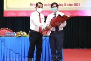 Chủ tịch HĐND tỉnh Đồng Nai Thái Bảo tặng hoa chúc mừng ông Nguyễn Sơn Hùng được bầu làm Phó chủ tịch UBND tỉnh. (Ảnh: TTXVN phát).