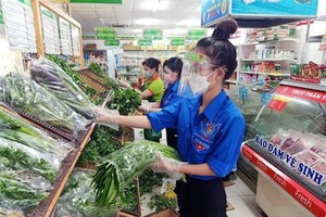 Thanh niên tình nguyện Thành phố Hồ Chí Minh 'đi chợ hộ' người dân trong những ngày giãn cách xã hội 'ai ở đâu ở yên đó.' (Ảnh: TTXVN phát).