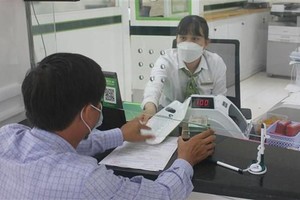 Khách hàng giao dịch tại Ngân hàng TMCP Ngoại thương Việt Nam chi nhánh tỉnh Kon Tum. (Ảnh minh họa: Dư Toán/TTXVN).