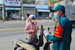 Lực lượng chức năng vận động người dân quay trở lại nơi tạm trú. (Ảnh: Chí Tưởng/TTXVN).