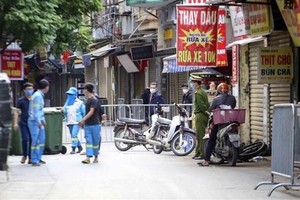 Lực lượng công nhân vệ sinh thu dọn rác thải tại khu vực phong tỏa phường Phú Đô, quận Nam Từ Liêm (Hà Nội). (Ảnh: Tuấn Đức/TTXVN).