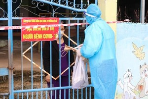 Nhân viên Trạm y tế phường Mỹ Hải, thành phố Phan Rang-Tháp Chàm đến thăm khám sức khỏe, cấp túi thuốc cho bệnh nhân mắc COVID-19 điều trị tại nhà. (Ảnh: Nguyễn Thành/TTXVN)