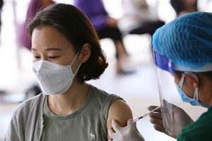 Tiêm vaccine phòng COVID-19 cho người nước ngoài. (Ảnh: Hoàng Hiếu/TTXVN).