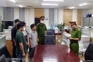 Lực lượng chức năng đọc lệnh bắt các bị can liên quan đến vụ án xảy ra tại Bệnh viện Đa khoa Đồng Nai, Công ty AIC và các đơn vị liên quan. (Ảnh: Phạm Kiên/TTXVN)