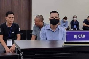 Bị cáo Việt (đeo khẩu trang, áo xanh) lừa đảo chạy vào ngành công an. (Nguồn: laodong.vn).