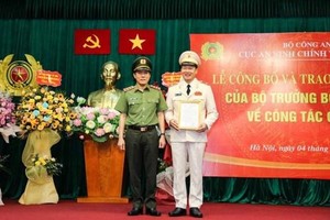 Thứ trưởng Lương Tam Quang trao quyết định, tặng hoa chúc mừng Thiếu tướng Vũ Hồng Văn, tân Cục trưởng Cục An ninh chính trị nội bộ. (Nguồn: Tiền Phong).