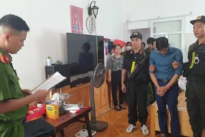 Phạm Trung Kiên (áo xanh than) nghe đọc lệnh khám xét khẩn cấp tại nhà riêng (Ảnh: PX03 Điện Biên).