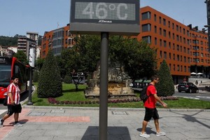Người dân đi qua một biển báo nhiệt độ 46 độ C tại Bilbao, Tây Ban Nha ngày 17/6. (Ảnh: Reuters)