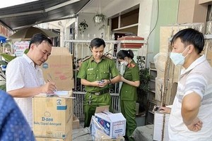 Lực lượng công an kiểm đếm số lượng hàng hóa nghi vấn nhập lậu. (Ảnh: TTXVN phát)