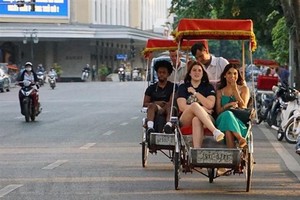 Du khách trải nghiệm du lịch quanh hồ Hoàn Kiếm bằng xíchlô. (Ảnh: Khánh Hòa/TTXVN)