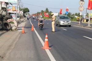 Kiểm tra phương tiện xe môtô lưu thông trên Quốc lộ 1 thuộc huyện Châu Thành, Tiền Giang. (Ảnh: Minh Trí/TTXVN).