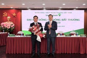 Ông Phạm Quang Dũng, Chủ tịch HĐQT Vietcombank (bên phải) tặng hoa chúc mừng ông Nguyễn Thanh Tùng - Phó tổng giám đốc phụ trách Ban điều hành đã được Đại hội bầu bổ sung là Thành viên HĐQT Vietcombank nhiệm kỳ 2018 - 2023.
