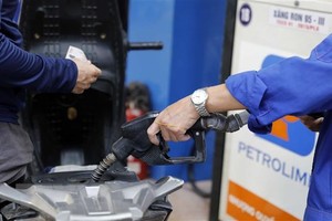 Mua, bán xăng tại một điểm kinh doanh xăng, dầu của Petrolimex ở Hà Nội. (Ảnh: Trần Việt/TTXVN)