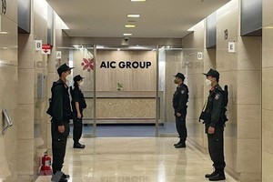 Lực lượng Cảnh sát điều tra làm nhiệm bảo vệ trong quá trình khám xét tại trụ sở Công ty AIC, 69 phố Tuệ Tĩnh, ngày 29/4/2022. (Ảnh: Phạm Kiên/TTXVN).