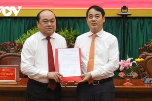 Bí thư Tỉnh ủy Hậu Giang Nghiêm Xuân Thành trao quyết định của Ban Bí thư cho ông Trần Văn Chính (bìa trái).