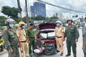 Lực lượng chức năng, Công an thành phố Dĩ An, tỉnh Bình Dương, bắt quả tang đối tượng Võ Đức Quốc Trung vận chuyển cung cấp thuốc lá lậu. (Ảnh: TTXVN phát)