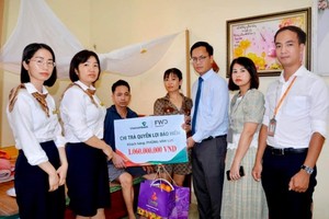 Đại diện Vietcombank Hải Dương và đại diện FWD Việt Nam thăm hỏi, tặng quà và trao biển tượng trưng chi trả quyền lợi bảo hiểm cho anh Phùng Văn Lực.