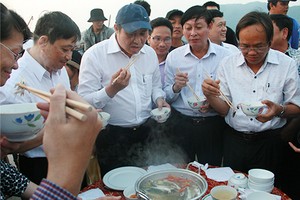 Ông Huỳnh Đức Thơ (người đội mũ) đã trực tiếp chế biến và thưởng thức hải sản của ngư dân ngay tại cảng cá. Ảnh: Đ.X.