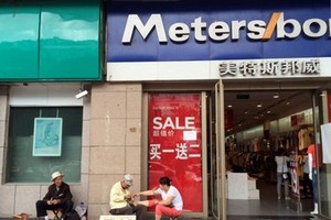 Người dân ngồi bên ngoài một khu mua sắm tại đây. Ảnh: Reuters