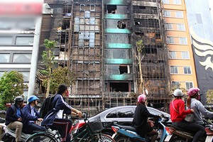 Nhiều người đi đường đều ngoái nhìn 4 ngôi nhà bị cháy. Ảnh:Phương Hòa.