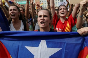 Một phụ nữ cầm cờ ly khai của Catalonia trên đường phố Barcelona hôm 2/10. Ảnh:Reuters.