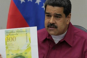 Tổng thống Venezuela giới thiệu thiết kế tờ 100.000 bolivar. Tờ tiền chỉ in số 100 nhưng dòng chữ tiếng Tây Ban Nha có ghi rõ "cien mil bolivares", có nghĩa là "một trăm nghìn bolivar".Ảnh: Reuters