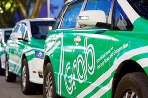 Taxi công nghệ Grab di chuyển trên đường phố.