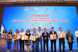 Nhà báo Tô Ngọc Doanh (thứ tư từ phải sang) đại diện nhóm tác giả Báo Đầu tư nhận giải Nhì Giải báo chí toàn quốc về Phòng chống thiên tai năm 2019.