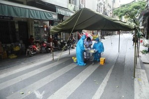 Nhân viên y tế quận Hoàn Kiếm lấy mẫu xét nghiệm COVID-19 cho các trường hợp có nguy cơ cao. (Ảnh: TTXVN).