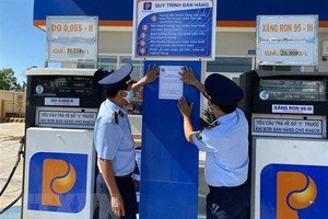 Lực lượng quản lý thị trường tỉnh Ninh Thuận dán thông báo đường dây nóng tiếp nhận thông tin phản ánh hành vi vi phạm trong hoạt động kinh doanh xăng dầu.