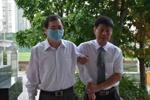Ông Vũ Huy Hoàng được luật sư dìu đến tòa.