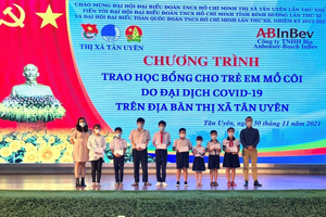Anh Trương Văn Toàn (Giám đốc Pháp lý, Đối ngoại và truyền thông Công ty TNHH Bia Anheuser-Busch InBev) và chị Đinh Ngọc Thúy Vy (Phụ trách truyền thông) trao học bổng cho các trẻ em mồ côi tại thị xã Tân Uyên.