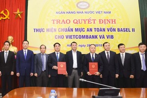 Thống đốc NHNN Việt Nam Lê Minh Hưng (đứng giữa) cùng Phó thống đốc NHNN Đoàn Thái Sơn (thứ 3 từ trái sang) trao quyết định cho Vietcombank và VIB