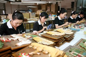 Công nhân Công ty Gia Long-TP HCM đang gia công hàng thủ công mỹ nghệ xuất khẩu Ảnh: Lê Toàn