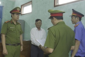 Tống đạt quyết định khởi tố bị can đối với Đàm Xuân Vinh (Ảnh: BCA)