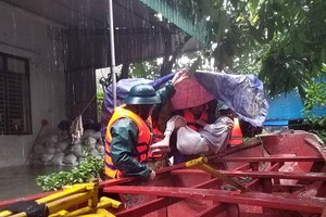 Lực lượng chức năng TP. Hà Tĩnh sơ tán dân vùng ngập sâu đến nơi an toàn. Ảnh P. Đức