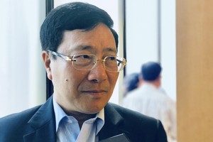 Phó Thủ tướng, Bộ trưởng Bộ Ngoại giao Phạm Bình Minh trao đổi tại hành lang Quốc hội.