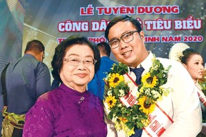 Phan Minh Tiến (bên phải) chụp ảnh cùng nguyên Phó chủ tịch nước Trương Mỹ Hoa tại Lễ tuyên dương công dân trẻ tiêu biểu TP.HCM 2020