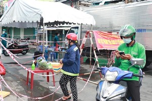 Hiện nhiều người dân thuộc khu vực phong toả nhưng không thuộc diện phải cách ly tại nhà đã có thể ra trạm kiểm soát Bùi Văn Ba nhận hàng hoá (Ảnh: Thị Hồng).