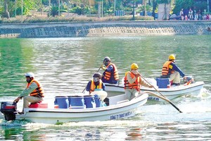 Vừa chỉ đạo miệng trái với văn bản giúp công ty của vợ hưởng lợi hàng chục tỷ đồng trong vụ mua chế phẩm Redoxy 3C, ông Chung vừa chủ động yêu cầu thanh tra, rồi ép buộc Thanh tra TP. Hà Nội thay đổi kết luận theo hướng không có sai phạm. Trong ảnh: Nhân viên Công ty Thoát nước Hà Nội dùng chế phẩm Redoxy 3C xử lý ô nhiễm nước hồ tại Hà Nội. Ảnh: H.N