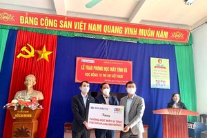 Ông Bùi Đức Hải, Phó tổng biên tập thường trực Báo Đầu tư (bìa trái) trao tặng phòng học máy tính trị giá 69.500.000 đồng cho Trường Tiểu học, Trung học cơ sở Thái An (huyện Thái Thụy, tỉnh Thái Bình)