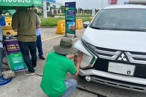 Nhân viên VETC đang dán thẻ thu phí tự động ETC cho khách trên cao tốc.