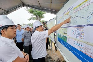 Bộ trưởng Kế hoạch và Đầu tư Nguyễn Chí Dũng xem bản đồ hướng tuyến cao tốc Tân Phú-Bảo Lộc trong chuyến kiểm tra thực địa dự án vào tháng 7/2022. (Ảnh: MAI VĂN BẢO, báo Nhân Dân).