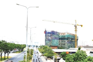 Một dự án nằm ngay mặt tiền đại lộ Đông Tây phải thi công cầm chừng do các vấn đề liên quan đến thủ tục và nguồn vốn. Ảnh: Trọng Tín