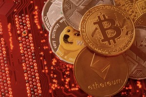 Các hình ảnh đại diện của tiền điện tử Bitcoin, Ethereum, DogeCoin, Ripple, Litecoin được đặt trên bo mạch chủ PC. Ảnh: Reuters