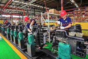 Công nhân làm việc trên dây chuyền lắp ráp động cơ tại một nhà máy sản xuất động cơ ở thành phố Thanh Châu, tỉnh Sơn Đông, Trung Quốc. Ảnh: AFP