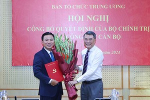 Trưởng ban Tổ chức Trung ương Lê Minh Hưng trao quyết định của Bộ Chính trị, tặng hoa chúc mừng ông Đỗ Trọng Hưng. Ảnh: TTXVN