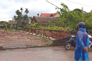 Một nhà đầu tư đội mưa để đi xem đất tại huyện Chương Mỹ. (Ảnh: Vũ Thanh)